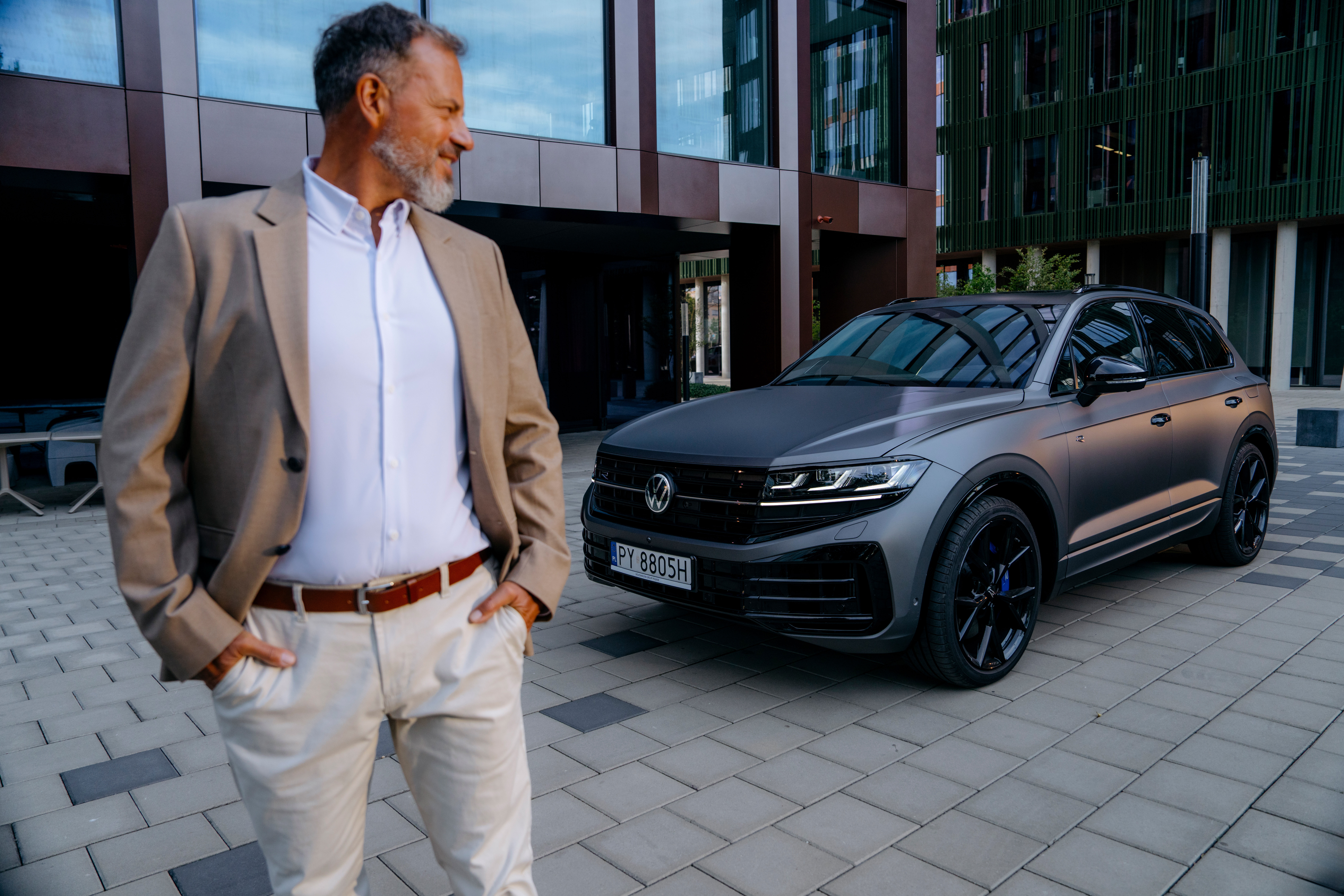 mężczyzna stoi obok volkswagena touareg