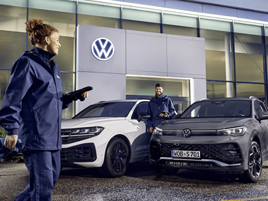 dwa samochody volkswagen zaparkowane przed salonem