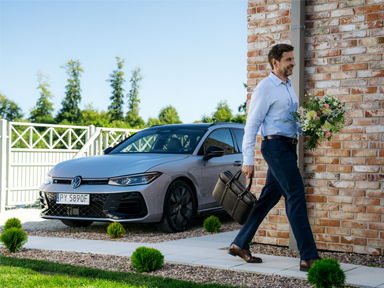 uśmiechnięty mężczyzna przechodzi obok volkswagena passat